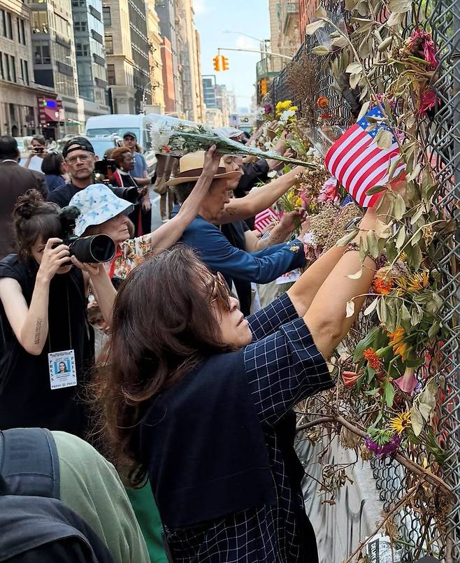 기자회견을 마친 뒤 참석자들이 뉴욕 맨해튼 ICE 연방청사 벽에 꽃을 달고 있다. 뉴욕성공회교구 제공