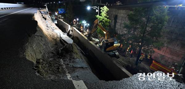 지난 7월 16일 오후 7시 4분께 오산시 가장교차로 고가도로의 옹벽이 무너지는 사고가 발생했다. 사진은 사고 현장에서 소방관들이 매몰된 차량을 구조하는 모습. 2025.7.16 /최은성기자 ces7198@kyeongin.com