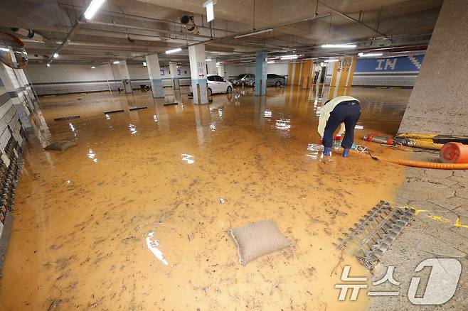 4일 전남 무안군 무안읍 한 아파트 주차장이 폭우에 침수돼 주민들이 흙탕물을 퍼내고 있다. 2025.8.4/뉴스1 ⓒ News1 김태성 기자