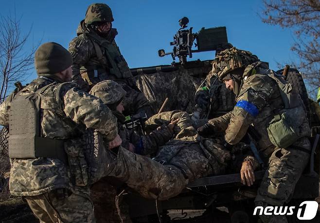 러시아의 우크라이나 침공이 계속되는 가운데 우크라이나 도네츠크주(州) 바흐무트 인근에서 우크라이나 군 장병들이 포격에 다친 전우를 이송하고 있다. <자료사진> (사진은 기사 내용과 무관함) / 뉴스1 ⓒ News1 2023.1.23. ⓒ 로이터=뉴스1 ⓒ News1 김성식 기자