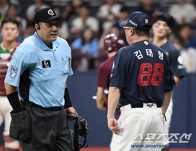 김태형 감독이 나와 심판에게 항의하는 모습. 걱정스러운 표정으로 바라보는 윤동희의 얼굴이 보인다.