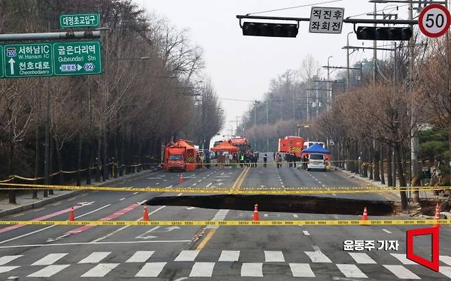 지난 3월 24일 서울 강동구 대명초등학교 인근 사거리에서  4개차로에 걸친 '대형 싱크홀(땅꺼짐)' 이 발생했다. 25일 사고 현장 주변이 통제되고 있다. 싱크홀에는 승용차 1대와 오토바이 1대가 빠졌으며, 승용차 탑승자 1명은 인근 병원으로 이송됐다. 현재 싱크홀 아래에는 오토바이 운전자 1명이 매몰돼 있다. 깊이는 30m로 추정된다. 2025. 03. 25 윤동주 기자