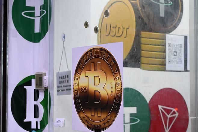 지난달 29일 홍콩의 한 가상자산 매장에 비트코인과 스테이블코인 테더(USDT)의 아이콘이 붙어 있다. /AFP연합뉴스