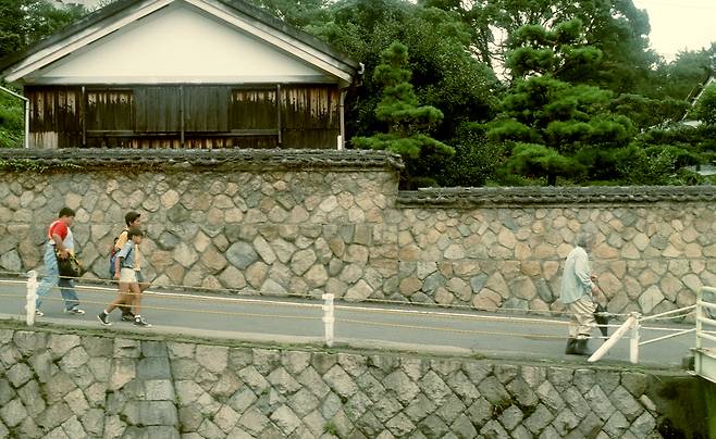 소마이 신지 감독은 멀리서 등장 인물들의 동선을 비추는 롱테이크를 자주 활용한다. 영화 <여름정원> 속 세 아이들이 마을의 독거 노인의 뒤를 몰래 따라가고 있다. 찬란 제공