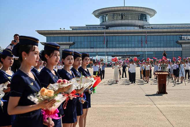 North Korean women wait with bouquets of flowers on the tarmac at Pyongyang International Airport on July 28 during a ceremony welcoming the first direct flight from Moscow to the North Korean capital in decades. [AP/YONHAP]