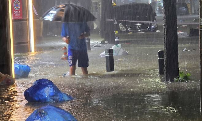 지난 3일 광주 북구 운암동 도심에서 한 시민이 침수된 거리를 이동하고 있다. 연합뉴스