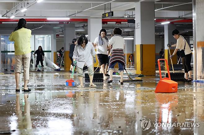흙탕물 범벅 된 무안군보건소 (무안=연합뉴스) 정다움 기자 = 호우 특보가 발효돼 시간당 142.1㎜의 집중 호우가 쏟아진 4일 오전 전남 무안군 군 보건소 지하 주차장이 빗물에 잠겨 직원들이 배수 작업을 하고 있다. 2025.8.4 daum@yna.co.kr
