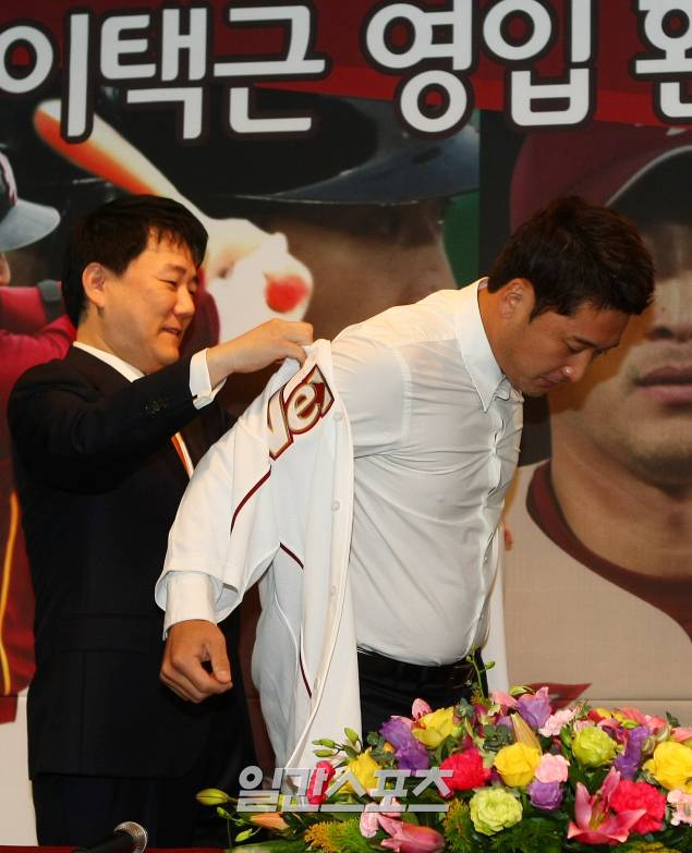 2011.11.29 <이택근 환영식 및 기자회견>29일 오전 서울 목동구장에서 열린 넥센 히어로즈의 이택근 영입 환영식 및 기자회견에서 이장석 대표가 이택근에게 유니폼을 입혀주고 있다. 김민규 기자