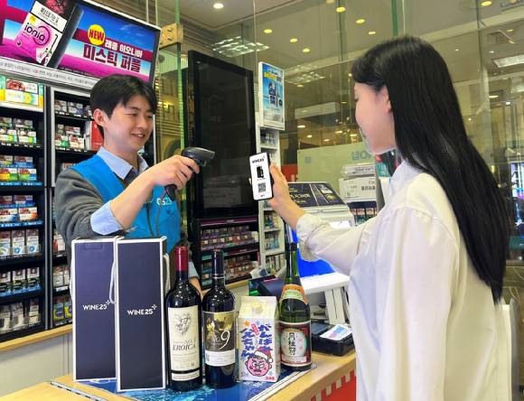 모델이 GS25 매장에서 와인25플러스 픽업 서비스를 이용하고 있는 모습. [사진=GS25]