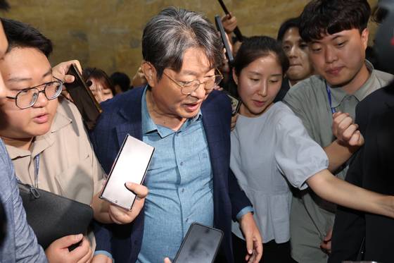 Lee Choon-suak, a Democratic Party lawmaker and chair of the National Assembly’s Legislation and Judiciary Committee, tries to walk past swarms of reporters on Aug. 5 after attending the National Assembly's plenary session. [NEWS1]