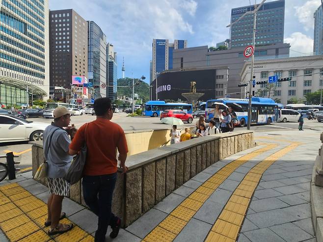 5일 오후 신세계백화점에서 쇼핑하던 외국인 관광객이 멀리서 백화점을 바라보고 있다. 일부 시민들은 지하보도를 이용해 현장에서 벗어나고 있다./사진=박상혁 기자.