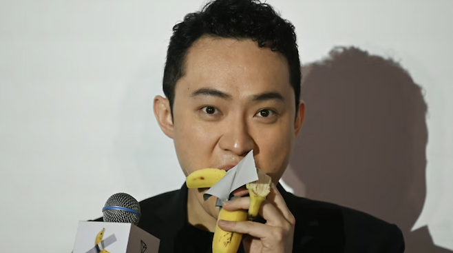지난해 11월 마우리치오 카텔란 작품 ‘코미디언’을 86억7000만원에 낙찰받은 30대 홍콩 암호화폐 사업가인 저스틴 선이 작품의 바나나를 떼어내 먹는 모습. [APF/연합]