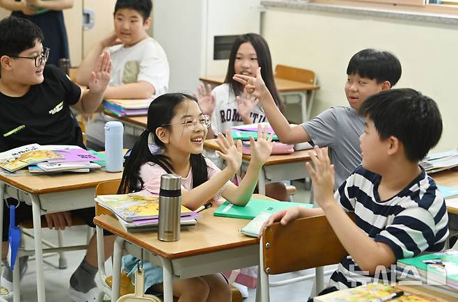 [수원=뉴시스] 김종택 기자 = 5일 여름방학을 마치고 개학한 경기 수원시 영통구 잠원초등학교 4학년2반 학생들이 오랜만에 만난 친구들과 반갑게 인사하고 있다. 2025.08.05. jtk@newsis.com