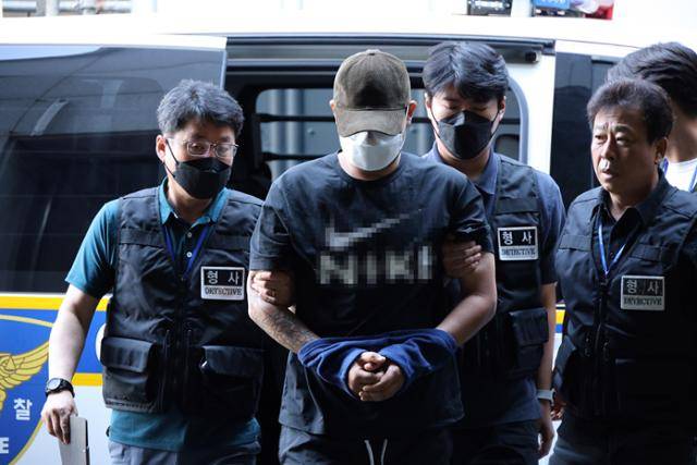 5일 병원에서 퇴원한 대전 교제 살인 피의자가 조사를 받기 위해 대전 서부경찰서로 들어가고 있다. 모자와 마스크로 얼굴을 가린 피의자는 "혐의를 인정하나" "왜 흉기를 휘둘렀나" 등 취재진 질문에 아무런 대꾸도 하지 않았다. 대전=연합뉴스