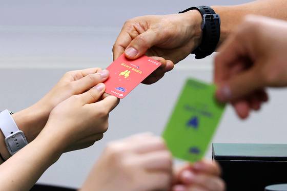 민생회복 소비쿠폰 지급 사흘째인 지난달 23일 오후 광주광역시 서구의 한 행정복지센터에서 주민들이 현물 카드를 지급받고 있다. 연합뉴스