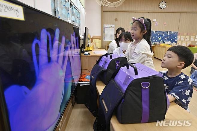 [광주=뉴시스] 박기웅 기자 = 광주 북구보건소 주최로 지난해 7월 18일 북구청어린이집에서 열린 여름철 질환 예방을 위한 '올바른 손씻기 교실에서 감염병관리팀 직원들이 아이들에게 뷰박스를 이용해 손을 씻기 전과 후 청결상태를 보여주고 있다. (사진은 기사와 관련이 없습니다.) 2024.07.18. pboxer@newsis.com