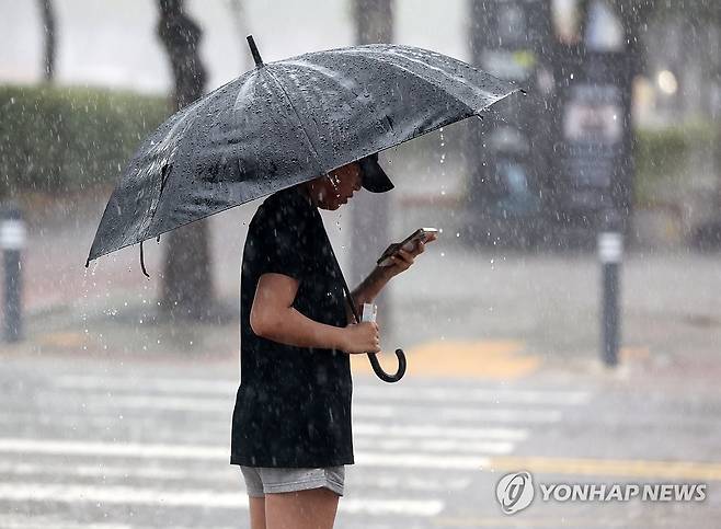 우산 쓴 시민 (광주=연합뉴스) 조남수 기자 = 17일 오전 광주 서구 치평동에서 한 시민이 우산을 쓰고 횡단보도 신호를 기다리고 있다. 2025.7.17 iso64@yna.co.kr