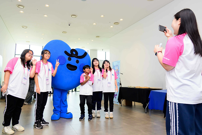 제일기획은 7일 삼성화재 글로벌캠퍼스 다목적홀(경기 고양시)에서 삼성 다문화청소년 스포츠 클래스 여름캠프를 개최했다. 삼성 다문화청소년 스포츠 클래스 마스코트와 함께 기념촬영을 하고 있다. [제일기획 제공]