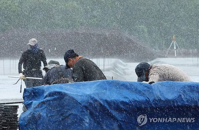 제주 곳곳 국지성 소나기 (제주=연합뉴스) 박지호 기자 = 6일 오전 제주시 구좌읍 송당리의 한 공사장에 국지성 소나기가 쏟아지자 작업자들이 급히 자재에 방수포를 씌우고 있다. 2025.8.6 jihopark@yna.co.kr