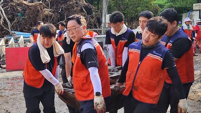 ▲ 강수현(왼쪽 두 번째) 양주시장과 봉사자들이 토사에 파묻힌 목재 작품을 건물 밖으로 옮기고 있다.