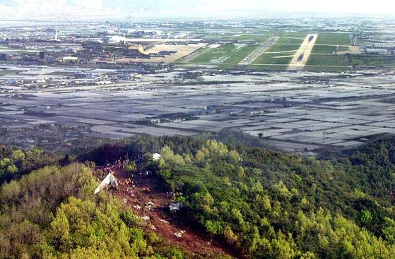 2002년 당시 하늘에서 내려다 본 경남 김해 돗대산 중국 여객기 추락사고 현장.산 너머로 김해 공항의 활주로가 보인다. 중앙포토