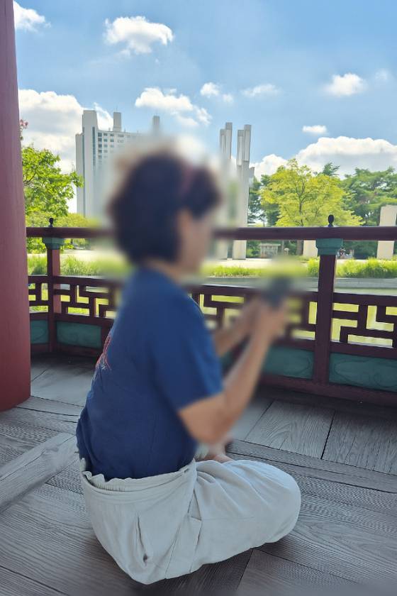 Ms. Jung watches a video clip showing her family in North Korea in an undated photo. The video arrived as proof that her remittance had been received. [JUNG]