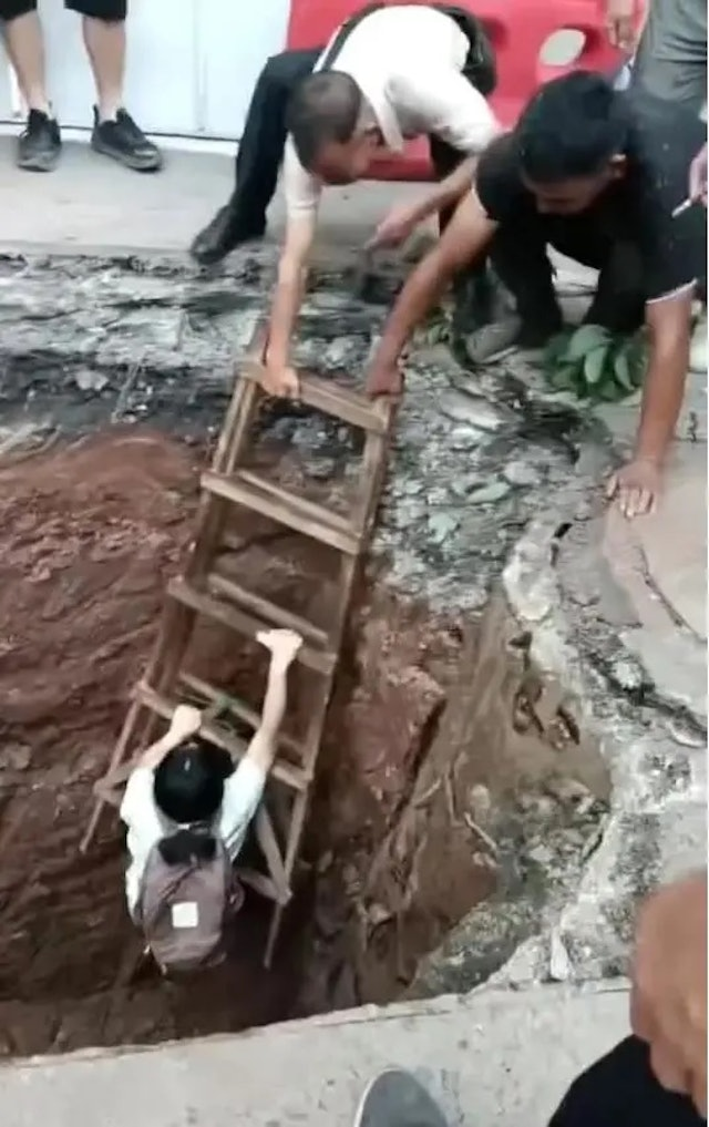 구덩이에 빠진 택시에 타고 있던 여성이 구조되고 있다. [사진 = 웨이보]