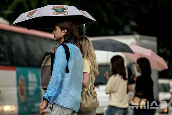 [서울=뉴시스] 정병혁 기자 = 소나기가 쏟아진 8일 서울 중구 청계천 일대에서 우산을 쓴 여행객이 이동하고 있다. 2025.08.08. jhope@newsis.com