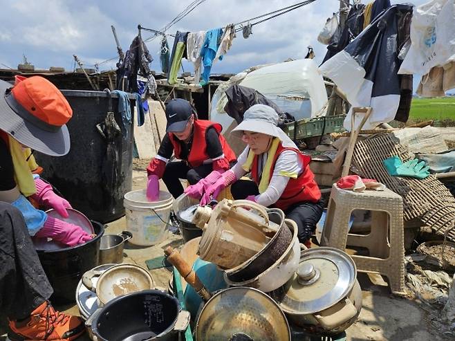 수해 현장 복구 봉사 - 김정재(오른쪽) 국민의힘 정책위의장이 지난달 22일 경북 포항북 국민의힘 당원들과 함께 충남 예산군 수해 현장에서 복구 작업을 돕는 봉사활동을 하고 있다.