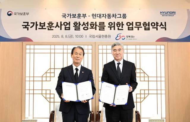 권오을(왼쪽) 국가보훈부 장관과 성 김 현대차그룹 전략기획담당 사장이 8일 국립서울현충원에서 국가 보훈 사업 활성화를 위한 업무협약을 체결한 뒤 협약서를 들어보이고 있다. 사진 제공=현대차그룹