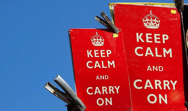 왕관 모양 아래로 '킵 캄 앤 캐리 온'이 적혀진 빨간 종이 2장