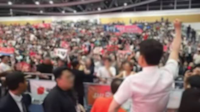 8일 대구 북구 엑스코에서 열린 국민의힘 제6차 전당대회 대구·경북 합동연설회에서 전한길 씨가 자리에서 일어나 의자 위에 올라선 뒤 한 손을 들어보이고 있다. (유튜브 캡처)