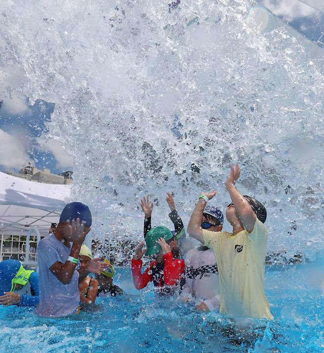 휴가철을 맞아 많은 이들이 찾는 바다와 계곡, 각종 물놀이장은 다양한 수인성 감염병이 확산되기 쉬운 환경이다. 지난달 22일 서울 광화문 광장에서 열리고 있는 ‘서울썸머비치’ 물놀이장에서 어린이들이 쏟아지는 물을 맞고 있다.  정효진 기자