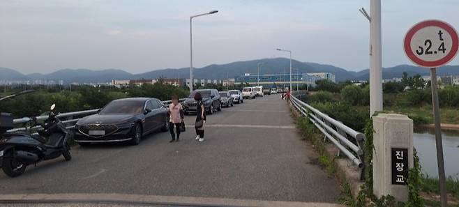 울산 북구 진장교에 불법주정차가 횡행해 보행자들이 차로 한가운데로 걸어가고 있다.