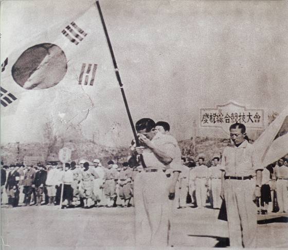 8일 서울 종로구 대한민국역사박물관에서 광복 80주년 기념 특별전 '태극기, 함께해 온 나날들'이 개막했다. 1945년 해방경축종합경기대회에서 태극기를 들고 눈물을 흘리는 손기정 선수의 사진도 만나볼 수 있다. 사진 대한민국역사박물관