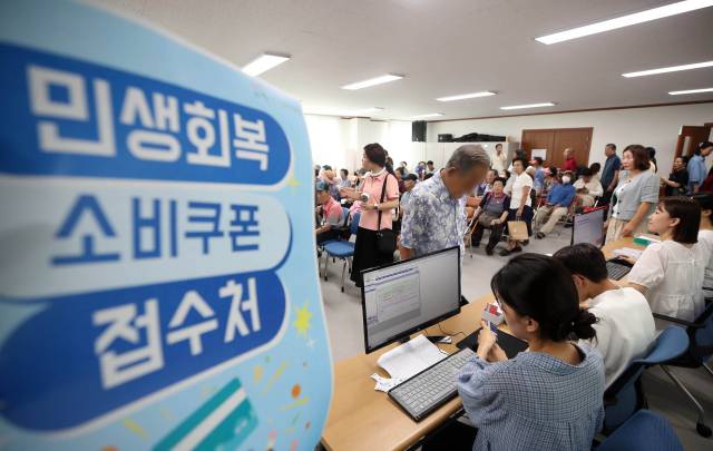 민생회복 소비쿠폰 지급 첫날인 21일 광주 북구 두암3동 행정복지센터에서 주민들이 신청절차를 밟고 있다. 연합뉴스