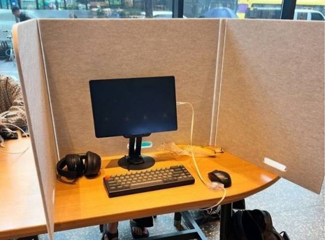 A photo shared on social media shows a Starbucks customer in South Korea working behind a three-sided partition with a full computer setup. (X)