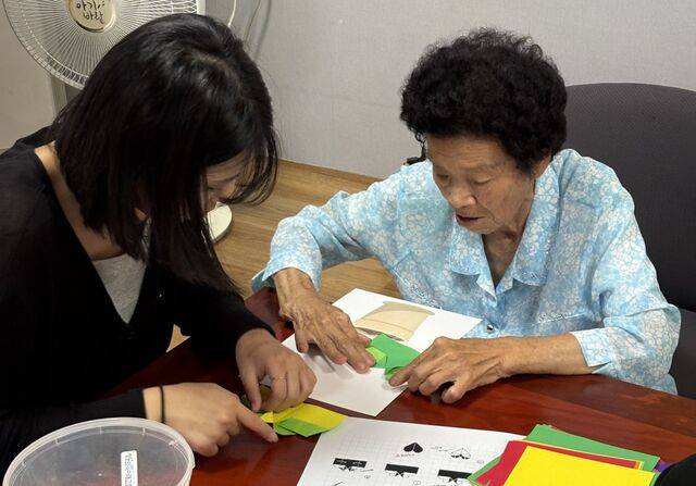 지난 1일 대전세상의빛이레교회 청년이 신기리2구 마을 회관에서 어르신에게 색종이 접기를 가르치며 함께 시간을 보내는 모습. 박지현 목사 제공