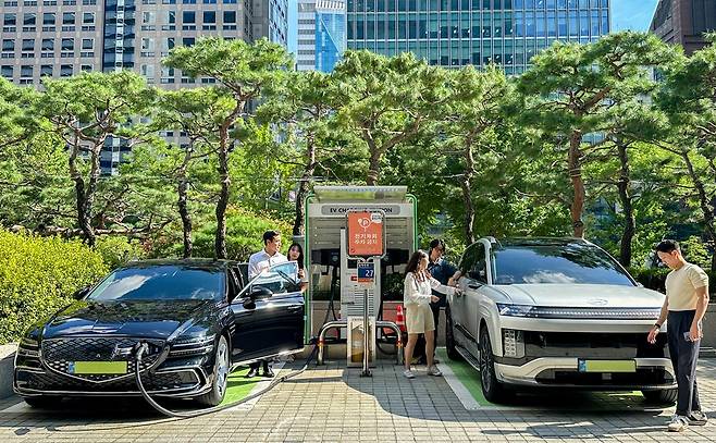 SK이노베이션 계열 직원들이 서울 종로구 SK서린빌딩에서 충전중인 현대자동차 대표 전기차 모델 아이오닉9과 eG80(전기화 모델)을 체험하고 있는 모습./사진제공=SK이노베이션