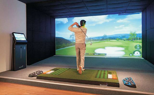서울 성동구 ‘포르쉐 서비스센터 성수’에 마련된 골프라운지에서 한 고객이 스크린 골프를 즐기고 있다.  포르쉐코리아 제공