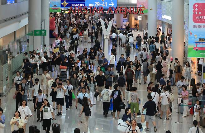 인천국제공항 면세점이 해외로 떠나는 여행객으로 붐비고 있다. <연합뉴스>