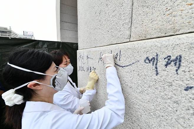 [서울=뉴시스] 11일 국가유산청 국립고궁박물관 관계자들이 낙서로 훼손된 서울 종로구 경복궁 광화문 석축의 긴급 복구 작업을 진행하고 있다. (사진=국가유산청 제공) 2025.08.11. photo@newsis.com *재판매 및 DB 금지