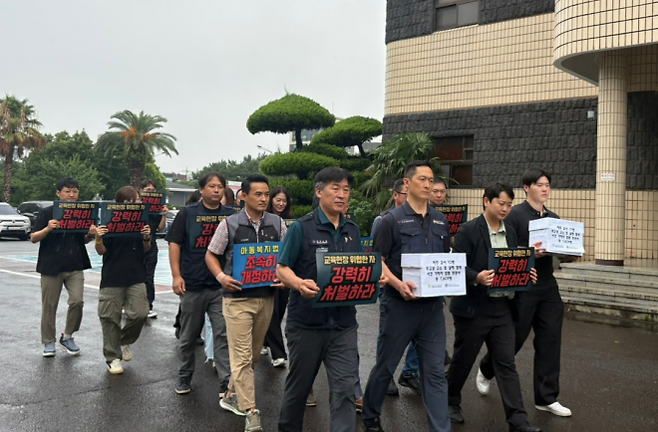 제주교사노동조합과 초등교사노동조합 등 10개 노조 단체가 11일 제주동부경찰서에 무고성 고소와 살해 협박 사건 가해자 구속기소와 엄벌 탄원을 요구하는 탄원서를 전달하러 이동하고 있다. 제주교사노조 제공