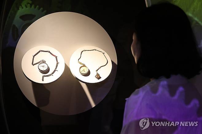 윤봉길 의사와 김구 선생이 맞바꾼 시계 (서울=연합뉴스) 강민지 기자 = 11일 서울 중구 덕수궁 돈덕전에서 열린 특별전 '빛을 담은 항일유산' 언론공개회에서 관계자가'윤봉길 의사와 김구 선생이 의거 당일 맞바꾼 회중시계'를 살펴보고 있다.  2025.8.11 mjkang@yna.co.kr