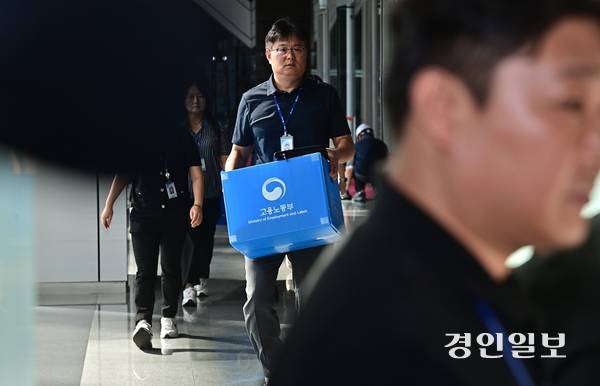경기남부경찰청과 고용노동부 관계자들이 12일 오전 인천 송도국제도시 포스코이앤씨 본사 사옥에서 압수품을 담기 위한 박스를 들고 이동하고 있다.  2025.8.12 /조재현기자 jhc@kyeongin.com