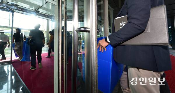 경기남부경찰청과 고용노동부 관계자들이 12일 오전 인천 송도국제도시 포스코이앤씨 본사 사옥에서 압수품을 담기 위한 박스를 들고 이동하고 있다.  2025.8.12 /조재현기자 jhc@kyeongin.com