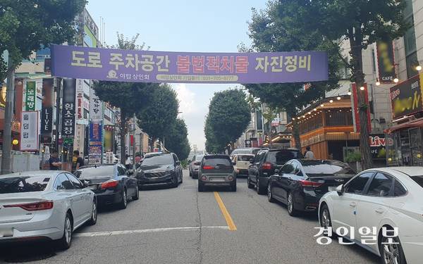 지난 11일 오후 6시께 야탑 먹자골목. 도로위에 차량들이 무단 추자돼 있고 그 사이를 다른 차량들이 힘겹게 빠져나가고 있다. 2025.8.11 성남/김순기기자 ksg2011@kyeongin.com