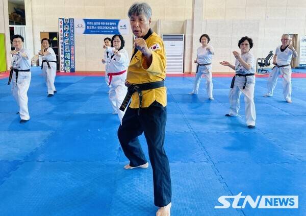 최재균 단장(중앙)이 강습생들 앞에서 경락품세 시범을 보이고 있다/ 사진= 세계어린이태권도연맹 제공.