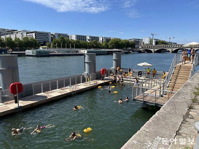 7일(현지 시간) 센강변의 공공 수영장에서 무료로 물놀이를 즐기는 시민들. 고물가로 휴가지를 찾지 않고 파리에 머물며 공공 시설을 이용하는 시민들이 많다. 파리=유근형 특파원 noel@donga.com