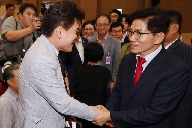 김문수 국민의힘 당대표 후보가 지난 8월4일 서울 여의도 국회 의원회관에서 투게더포럼이 주최한 시국토론회에 참석해 12·3 비상계엄 및 윤석열 전 대통령 옹호 논란 속 입당한 전한길 전 한국사 강사와 악수하고 있다.<연합뉴스 사진>